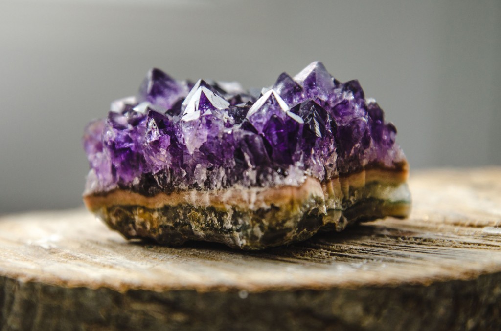 53651871 - raw violet amethyst rock with reflection on natural wood macro crystal ametist esoteric